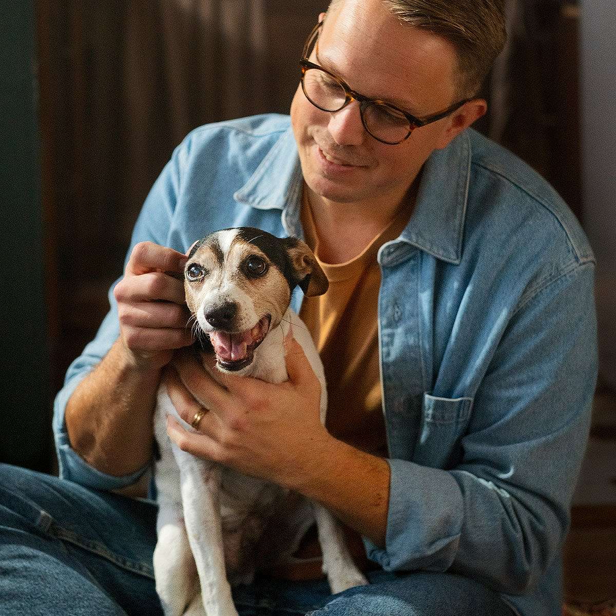 Dog cuddles with man